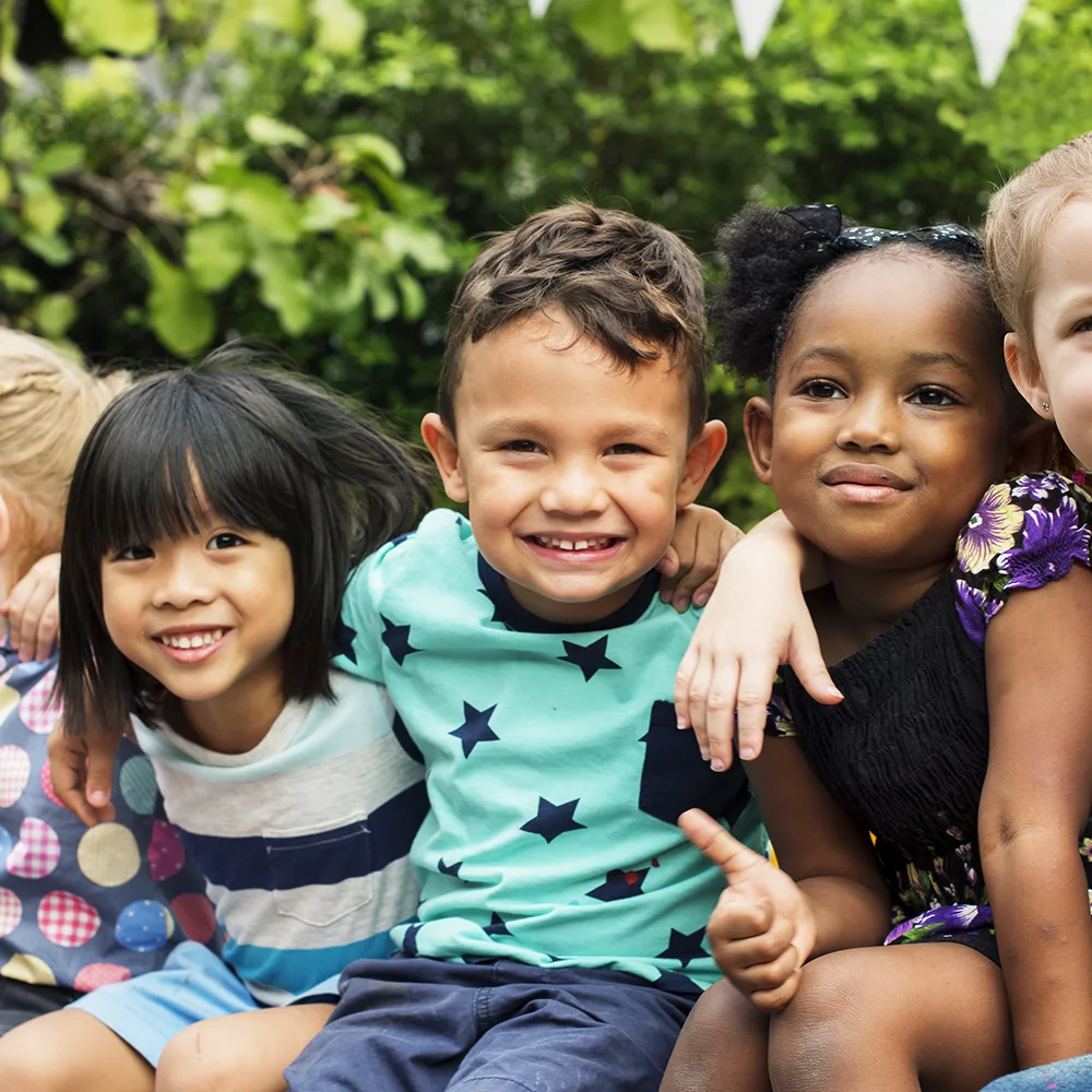 A group of children smiling outside of a Little Newtons daycare