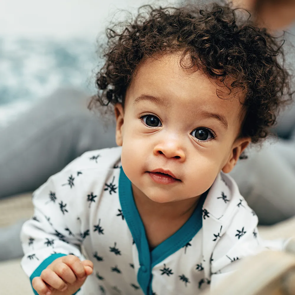 A young toddler with curly hair and pajamas