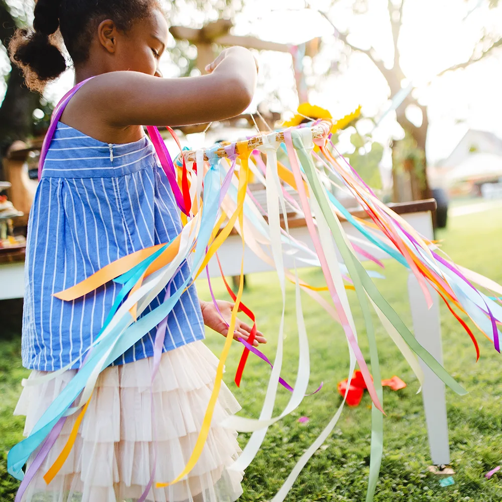 A child working on a colorful summer craft outside of a Little Newtons daycare