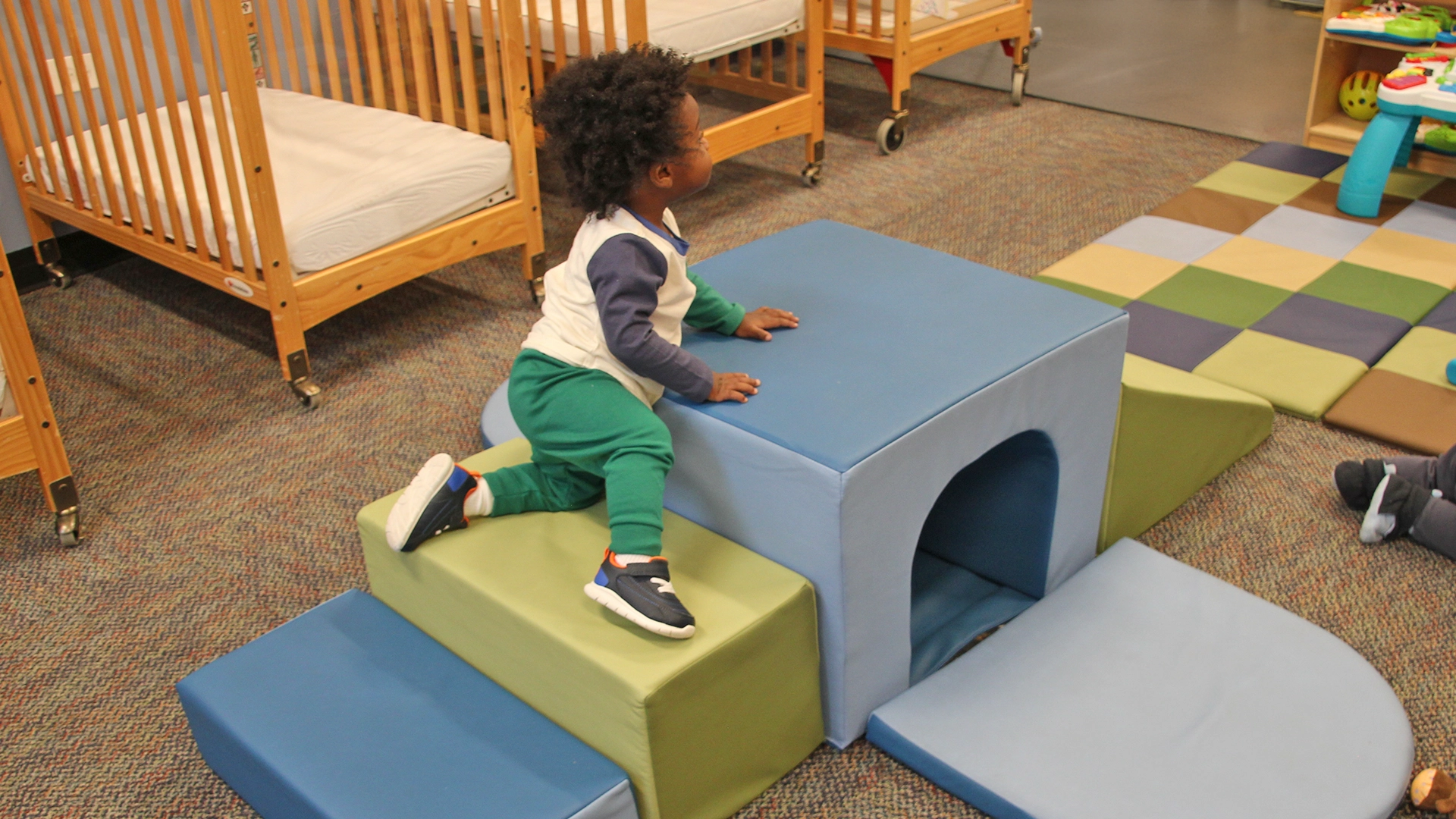 A child climbing on blocks at a Little Newtons daycare