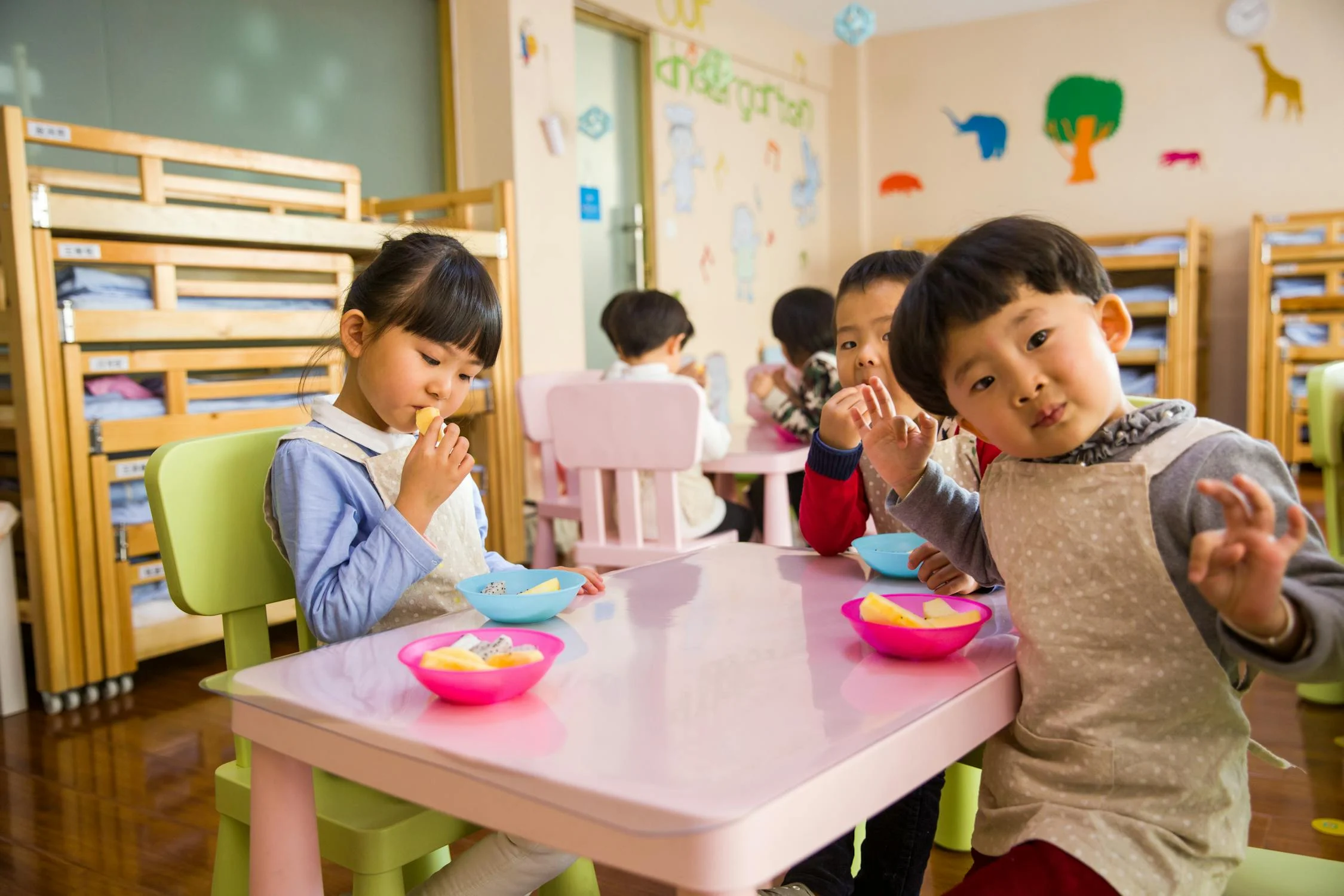 young children sitting at a small table at snack time