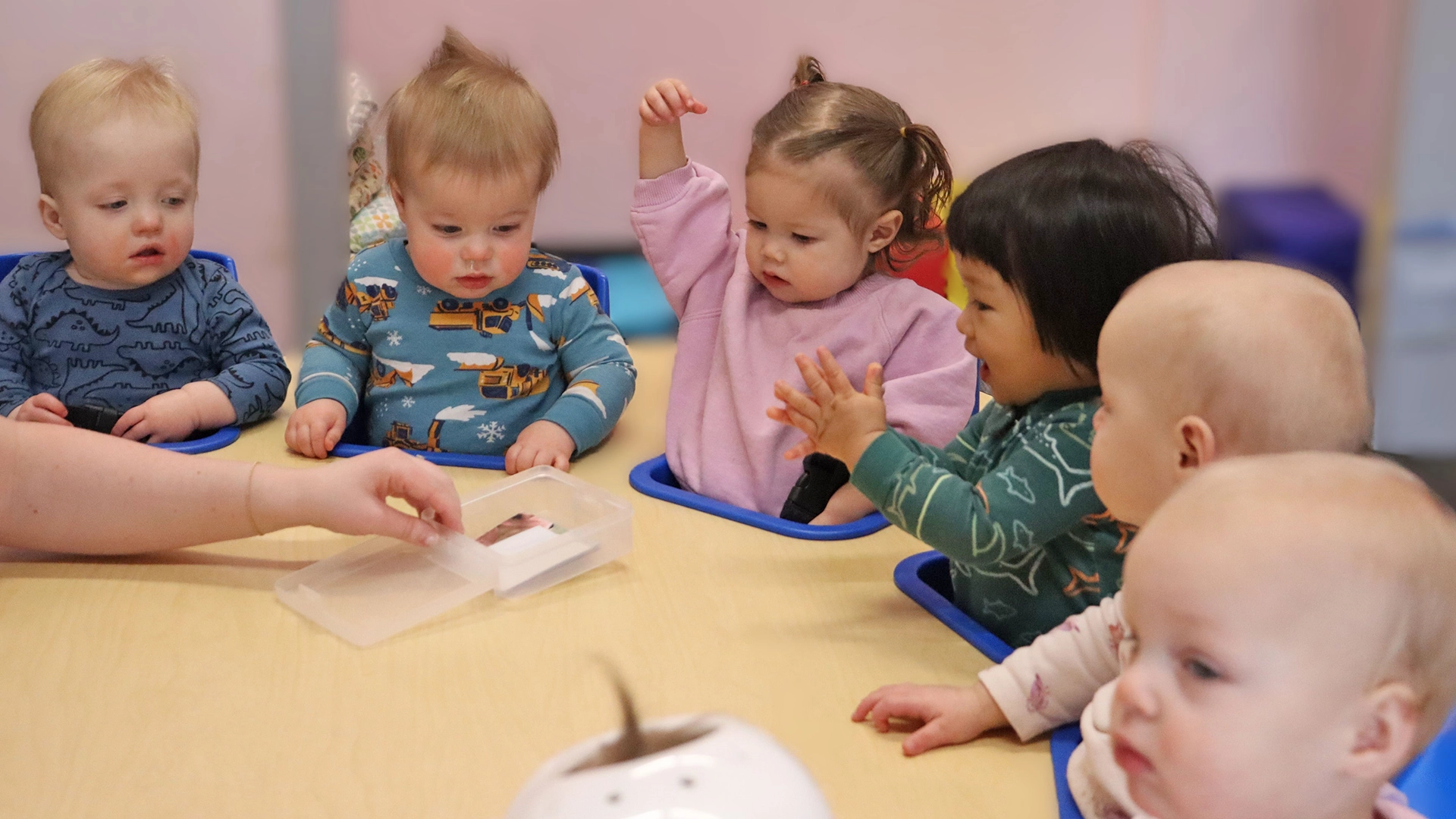 Toddlers sitting around a table at a daycare.