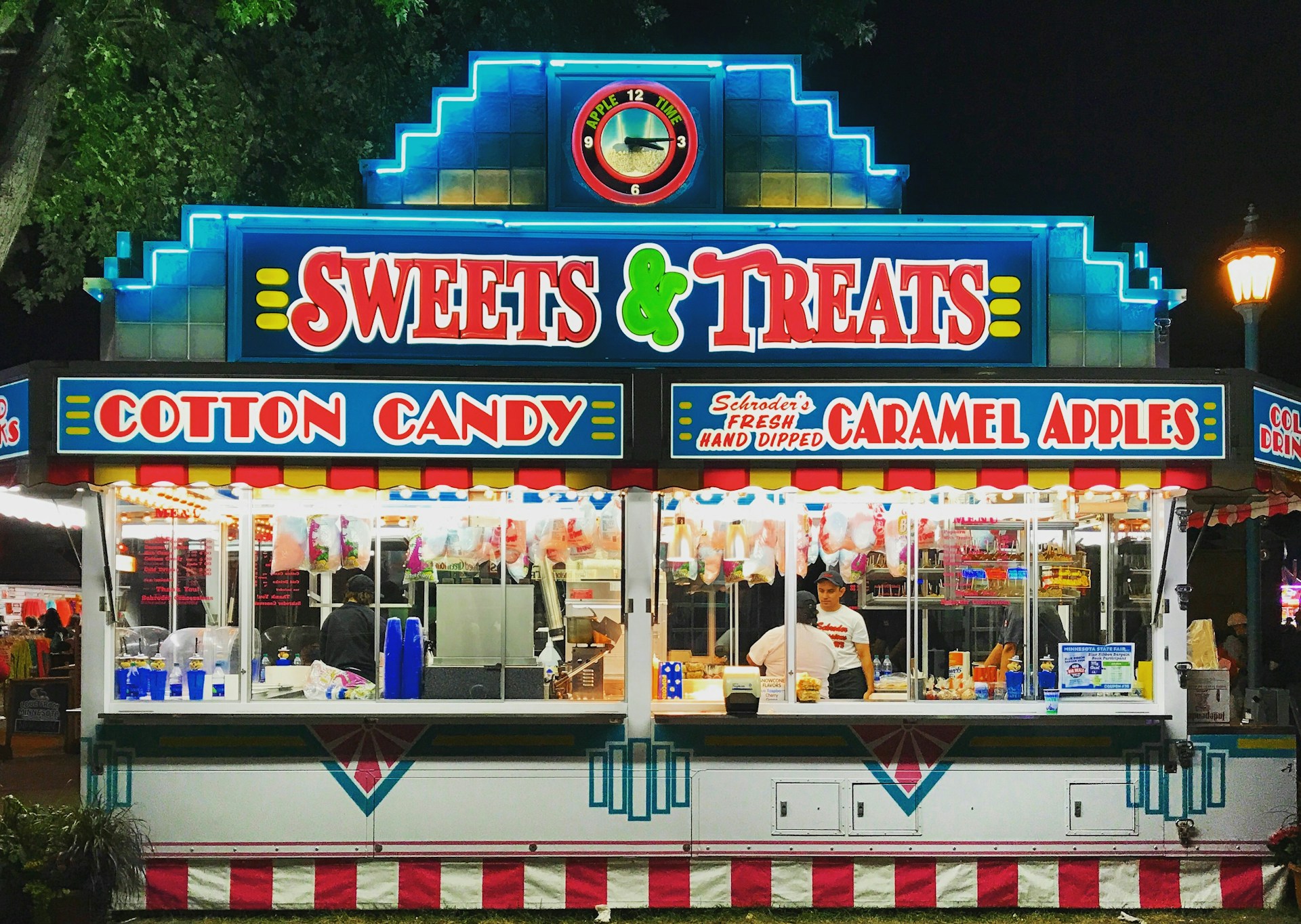 Brightly lit sign advertising cotten candy
