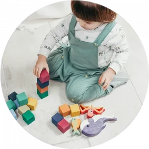 A child playing with blocks on the floor at a Little Newtons daycare