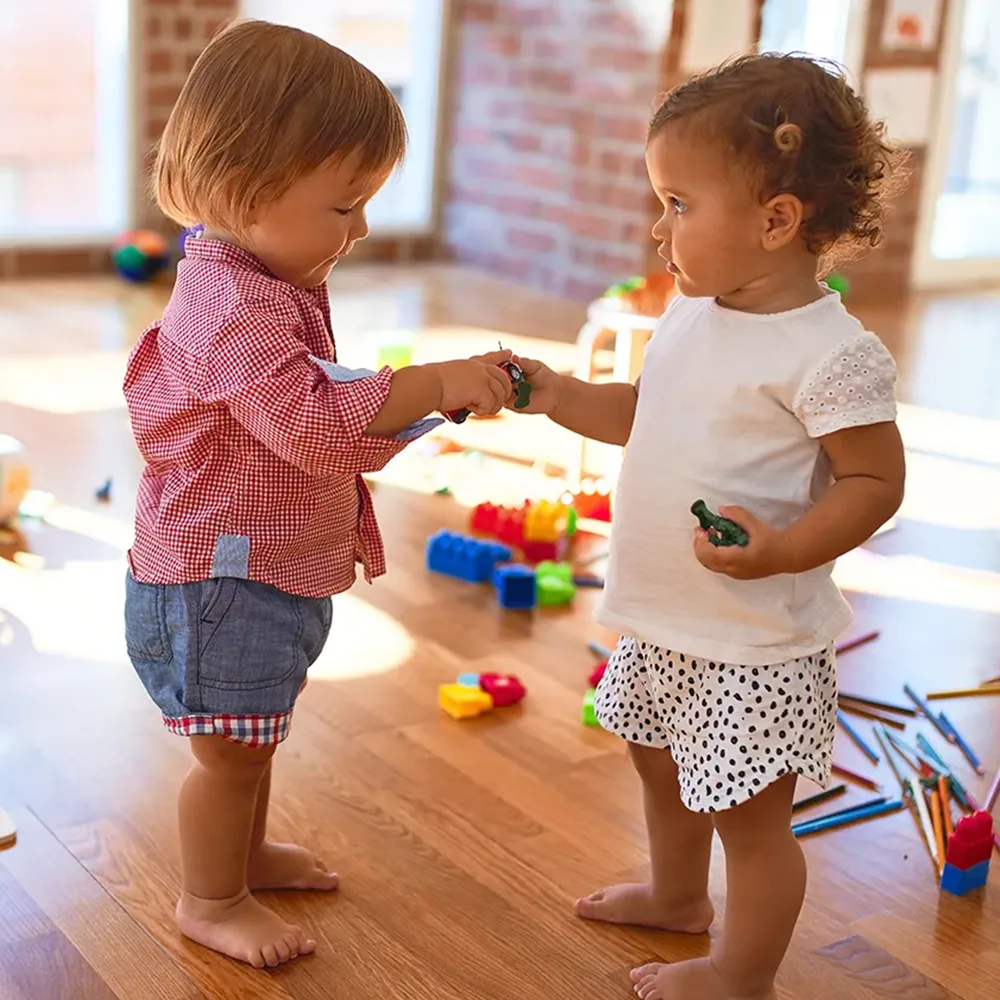 Two toddlers sharing toys at a Little Newtons daycare