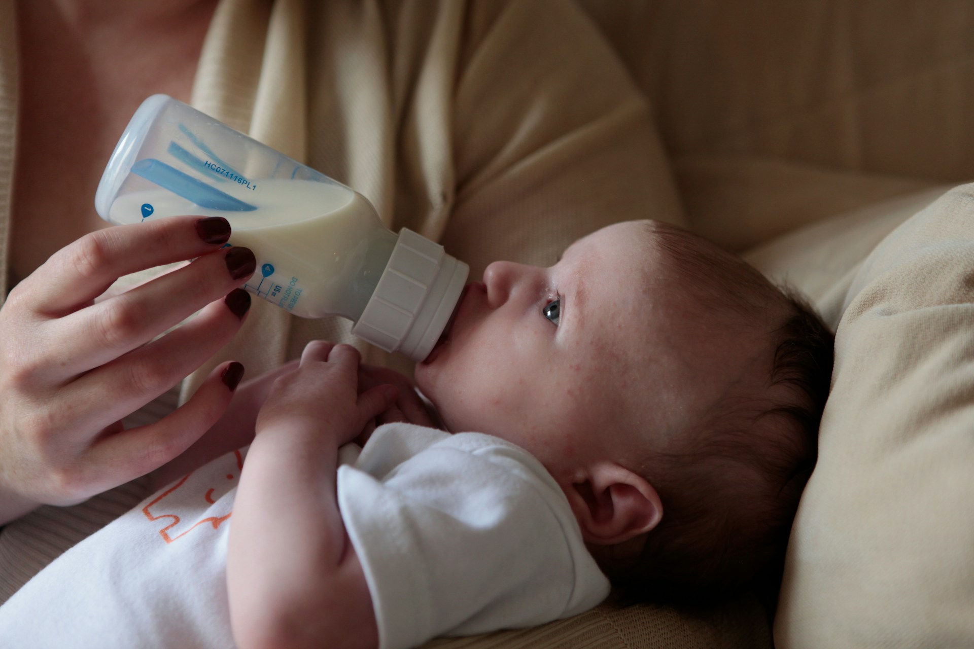 Woman feeding baby with bottle